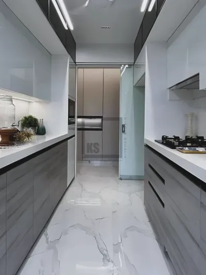 Even narrow galley kitchens can feel spacious and luxurious. In this design, we used a monochrome palette with high-gloss white upper cabinets and textured grey lower cabinets to create visual depth. The result is a sleek, efficient workspace that feels open and bright.