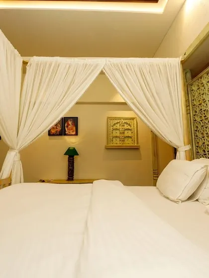 A low-angle shot from the foot of the canopy bed, looking towards the headboard and the room's intricate details, creating an immersive and inviting feel.