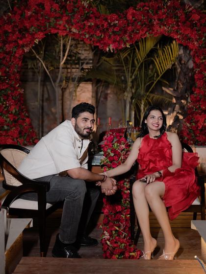 A romantic setting for a special celebration. The client's red dress stands out beautifully against the floral backdrop, making for a picture-perfect memory.