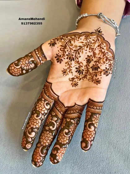 A simple yet stunning palm design. The focus is on the intricate floral pattern that fills the fingers, leaving the center of the palm open.