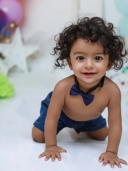 Capturing the personality of your little one is what I love most. This is a close-up portrait of a happy one-year-old boy, ready for his first birthday photoshoot.