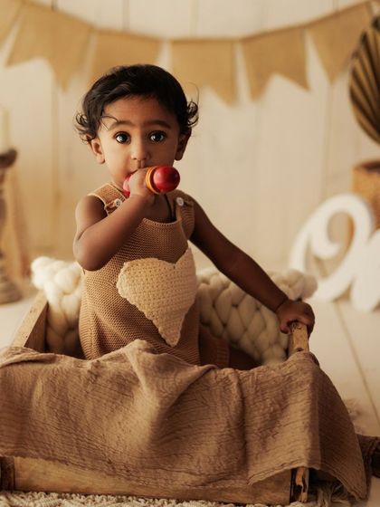 It's fun to be one. This setup is perfect for a first birthday or late sitter session, with a "One" sign and a rustic, warm theme.