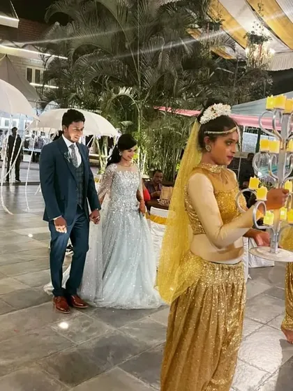My professional dance crew adds that touch of royal treatment. Here, they are dressed in full gold glam, lighting the way for the couple with candelabras and umbrellas for a truly grand welcome.