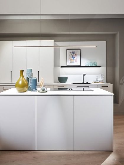 A crisp white kitchen from our Novelties 2025 collection. The minimalist island and handleless cabinets create a clean, modern aesthetic, perfect for any contemporary home.