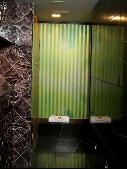 An interior shot of the steam room, showing the rich textures of the tiled walls and seating area. I've focused on creating a premium, serene atmosphere for your post-workout recovery.