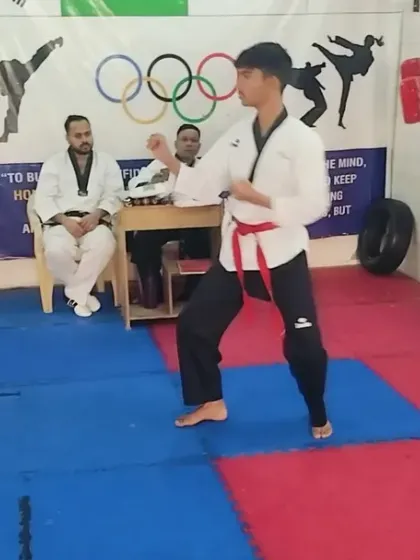 Another angle of a student performing his forms in front of the examiners during the black belt test.