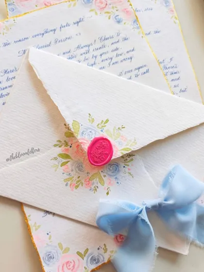 A handwritten letter and matching envelope, both adorned with vintage pastel roses. This showcases how I carry a cohesive design across different stationery elements.