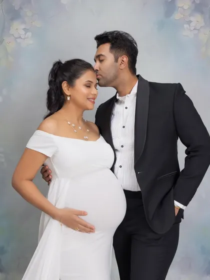 A classic portrait celebrating the couple's joy as they expect twins. The forehead kiss is a simple but powerful expression of love.