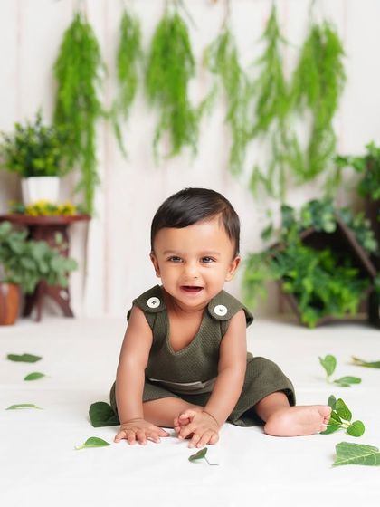 A classic sitter session portrait with a simple, natural theme. The greenery and his happy smile are all that's needed for a perfect photo.