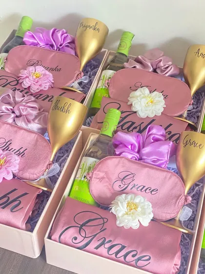 Time to celebrate with your girls! This bridesmaid hamper includes a personalized unbreakable wine glass, a mini bottle of white wine, a custom robe and eye mask, and a matching scrunchie. It's a party in a box!