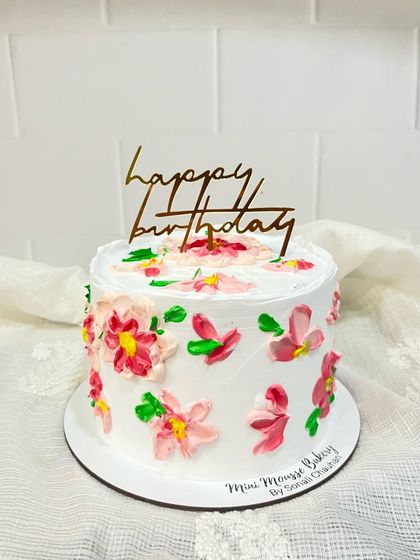 This hand-painted cake is one of my favorite styles to create. I use colored buttercream and a palette knife to paint abstract flowers directly onto the cake, making each one a unique piece of edible art.