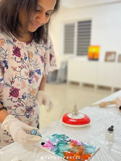 A participant adds more ink to her design, building up layers of color in her personalized journal cover.