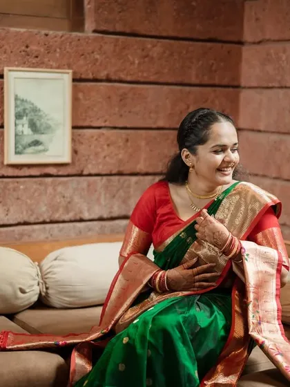 A candid moment of laughter. This bride, dressed in a traditional green and red saree, radiates pure joy, and we were there to capture that fleeting, beautiful expression.
