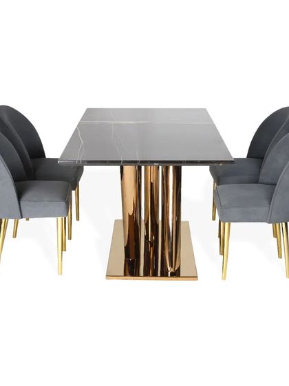 A variation of my pedestal dining table design, this piece features a black marble top on a fluted PVD gold base. The accompanying chairs are upholstered in grey suede with slender gold legs.