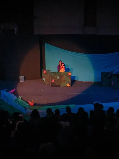 The amphitheatre is filled with an eager audience for 'Aisha's Journey'. Our outdoor performances create a unique and memorable atmosphere for families.