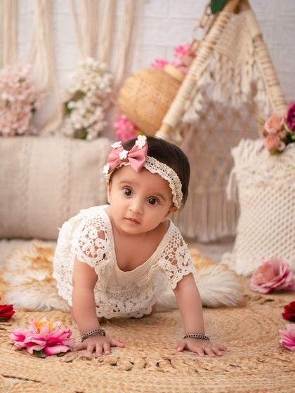 A crawling baby girl in a beautiful boho setup. The combination of lace, jute, and soft florals creates a timeless and elegant look.