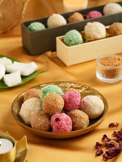 An assortment of colorful coconut laddoos arranged for a Diwali-themed shoot. We use props and backgrounds that complement the festive nature of the products.