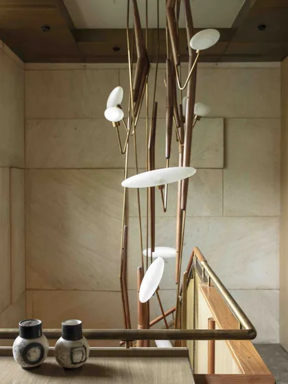 An overhead view of the 'Grasshopper' light installation, showcasing its organic, insect-like form. This piece transforms the staircase into a gallery-like experience from the moment of entry.