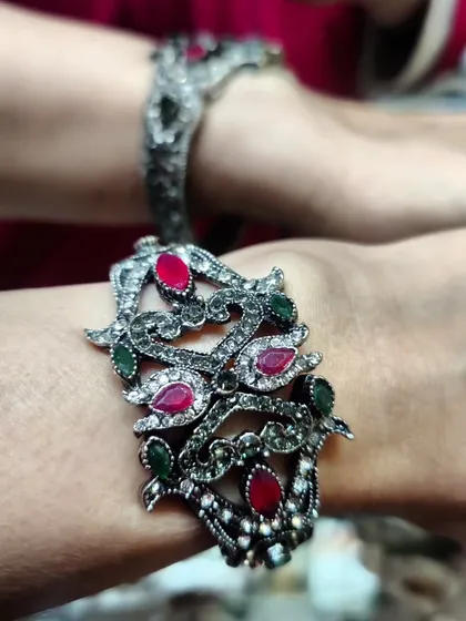 A new arrival for 2024, this stunning Victorian-style cuff features intricate metalwork with ruby and emerald coloured stones. It has a free-size magnetic clasp, making it both beautiful and easy to wear.
