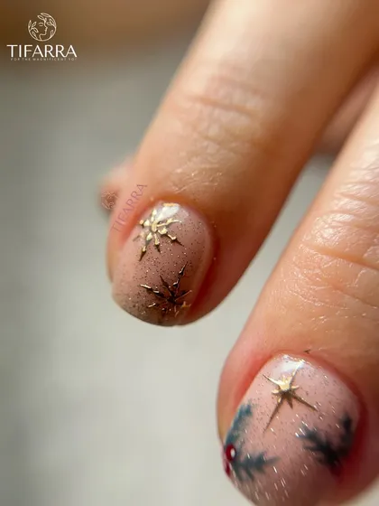 Delicate hand-drawn details wrapped in sparkle. A close-up of a Christmas nail with a 3D star and glitter.
