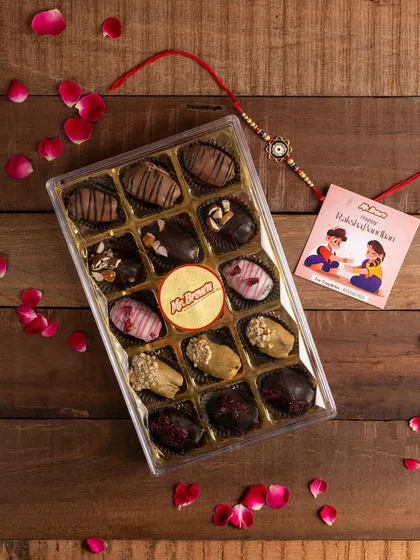 A festive flat lay of a Mr Brown chocolate dates hamper, styled with a rakhi and rose petals. This image is perfect for seasonal marketing, directly targeting the Raksha Bandhan gifting market.