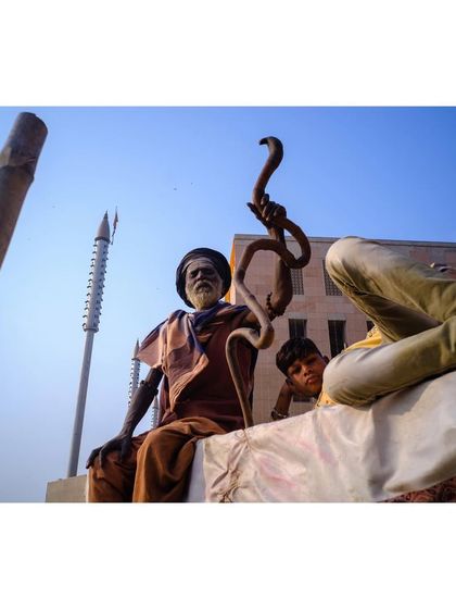 The color version of the sadhu with the snake staff. The blue sky and the earthy tones of his robes and the surroundings bring the scene to life.