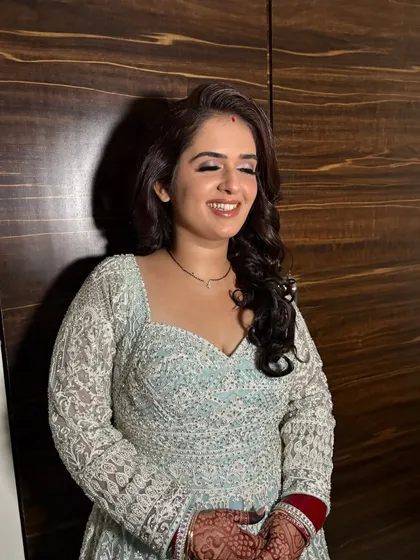 A happy client ready for a sangeet, with a soft glam look and beautiful curls.