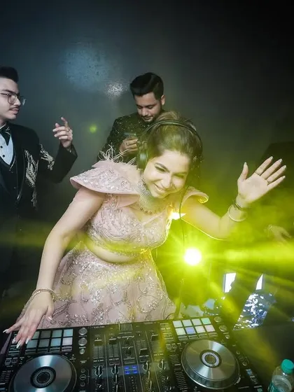 The bride enjoying her moment as the DJ, surrounded by friends.