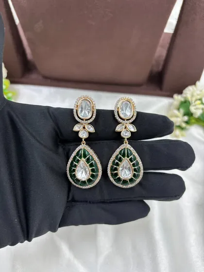 A close-up of the earrings from the green meenakari drop polki set.
