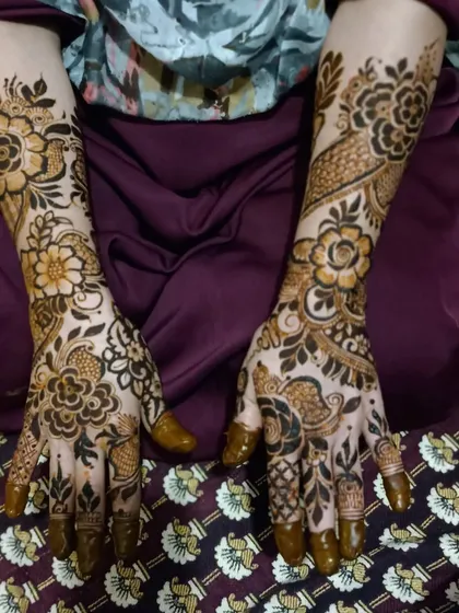 A beautiful and full floral mehndi design. The mix of large and small flowers creates a lush, garden-like effect on the hands.