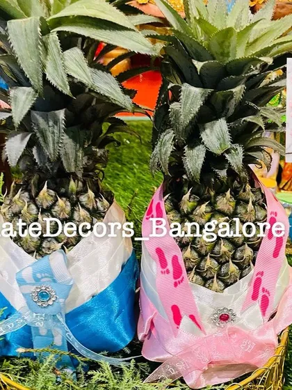 My signature pineapple bride and groom decoration. I dress up fresh pineapples in custom outfits, complete with little details, to represent the happy couple, adding a unique and fun element to wedding festivities.