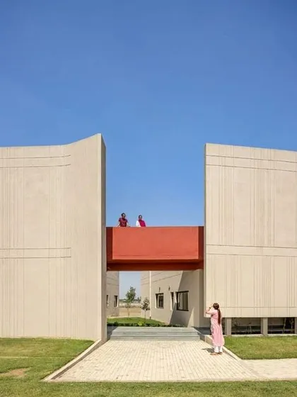 The architecture here is doing a job. These large, fortress-like walls at the SMBV school are shaped to manage Punjab's strong winds and intense sun, while the red bridge creates a pop of color and connection.