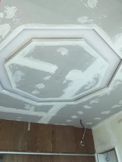 An octagonal tray ceiling design during the construction phase. The gypsum boards are being plastered to create a seamless surface.
