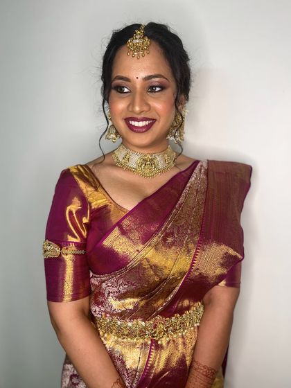 A happy bride ready for her big day. The makeup features a lovely plum lip color and softly defined eyes, creating a look of timeless elegance.