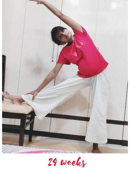 A modified side stretch using a chair for support at 24 weeks. It's all about finding what works for your body.