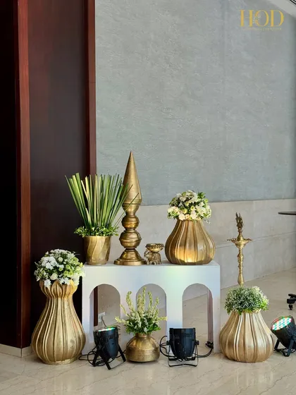 A simple and elegant corner with golden vases of different shapes and sizes, filled with white flowers, creating a clean and classic look.