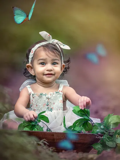 An enchanting outdoor portrait of a baby girl surrounded by the gentle flutter of butterflies. I love capturing these moments of pure joy and curiosity as little ones interact with the nature around them.