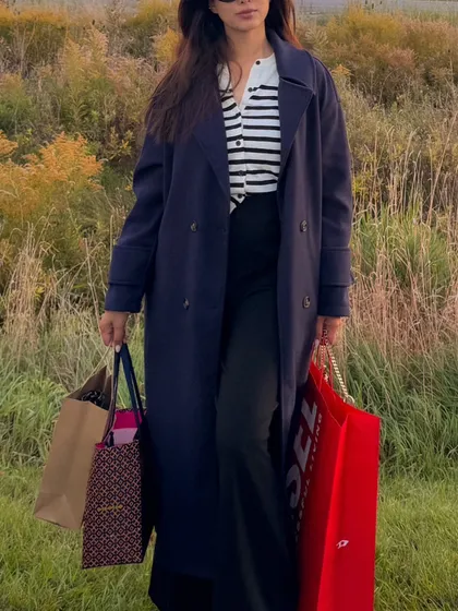 This image captures a full fall shopping day look. I'm wearing a classic trench coat layered over a striped cardigan, showing how to style a practical and fashionable outfit for a day out.