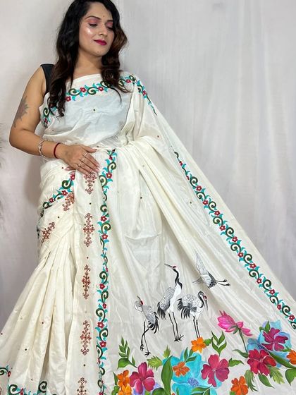 A stunning hand-painted and embroidered sari, featuring elegant cranes and vibrant flowers, a true masterpiece of wearable art.