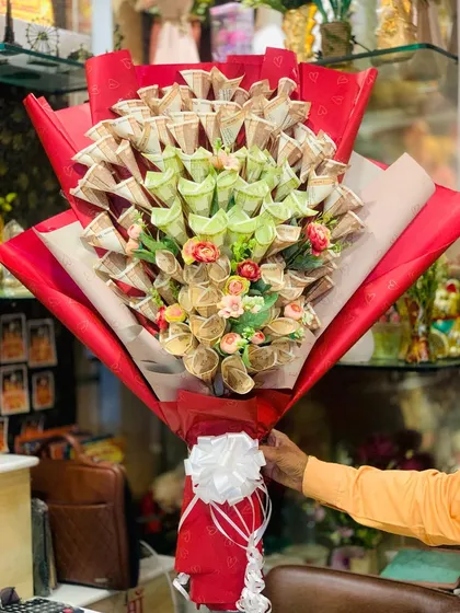 Another shot of the large money bouquet, highlighting the intricate folding of the currency notes and the small artificial flowers added for extra detail.
