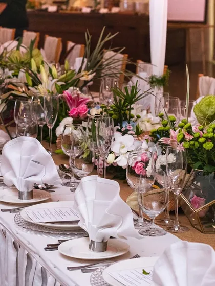 A beautiful sit down dinner setup at our Worli venue. The long table, adorned with tropical flowers and elegant place settings, offers a luxurious dining experience with a view.