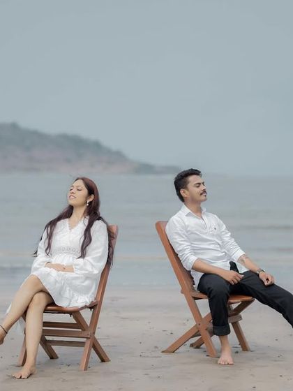 A peaceful moment captured on the beach, with the couple relaxing in separate chairs, conveying a sense of comfortable companionship.