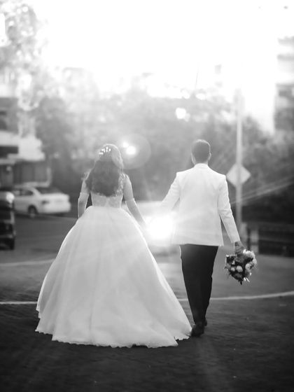 A dreamy black and white shot of the couple walking into the sunset. The lens flare adds a romantic and cinematic quality to this exit photo.
