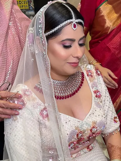 A candid moment of blessing. The soft bridal glam with pink eyeshadow looks beautiful from every angle.