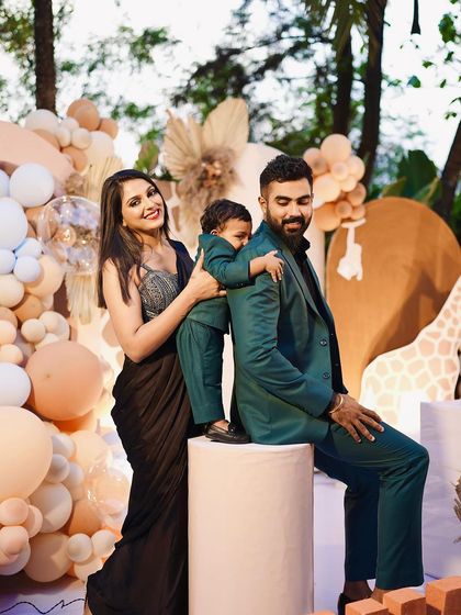 A beautiful family portrait from a jungle-themed birthday party. The stylish outfits and creative decor come together for a perfect photo opportunity.