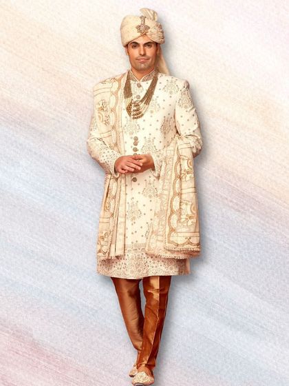 A full-length view of one of our classic groomswear rentals. The combination of ivory and gold is a timeless choice that exudes elegance and sophistication.