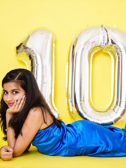 A glamorous pose from a 10th birthday shoot, with the birthday girl lying on her stomach next to her cake.