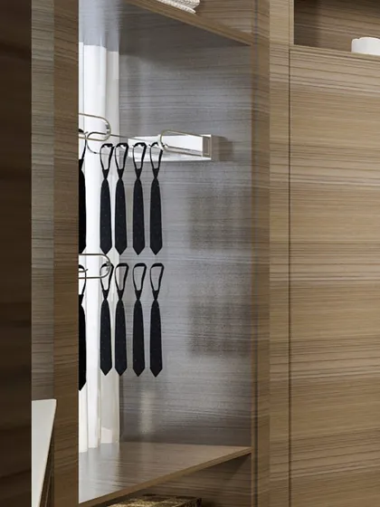 Our custom interiors include specialized accessories like this pull-out tie rack, ensuring every item has its own dedicated, organized space within your wood-finished wardrobe.