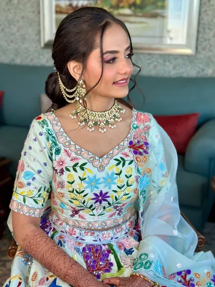 A side profile showing the elegant updo and the beautiful details of her jewelry and outfit. The makeup is soft and romantic.