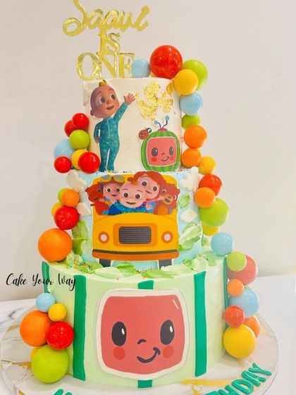 The wheels on the bus go round and round on this fun Cocomelon cake. This three-tier creation is perfect for a first birthday, featuring all the beloved characters and bright, happy colors.
